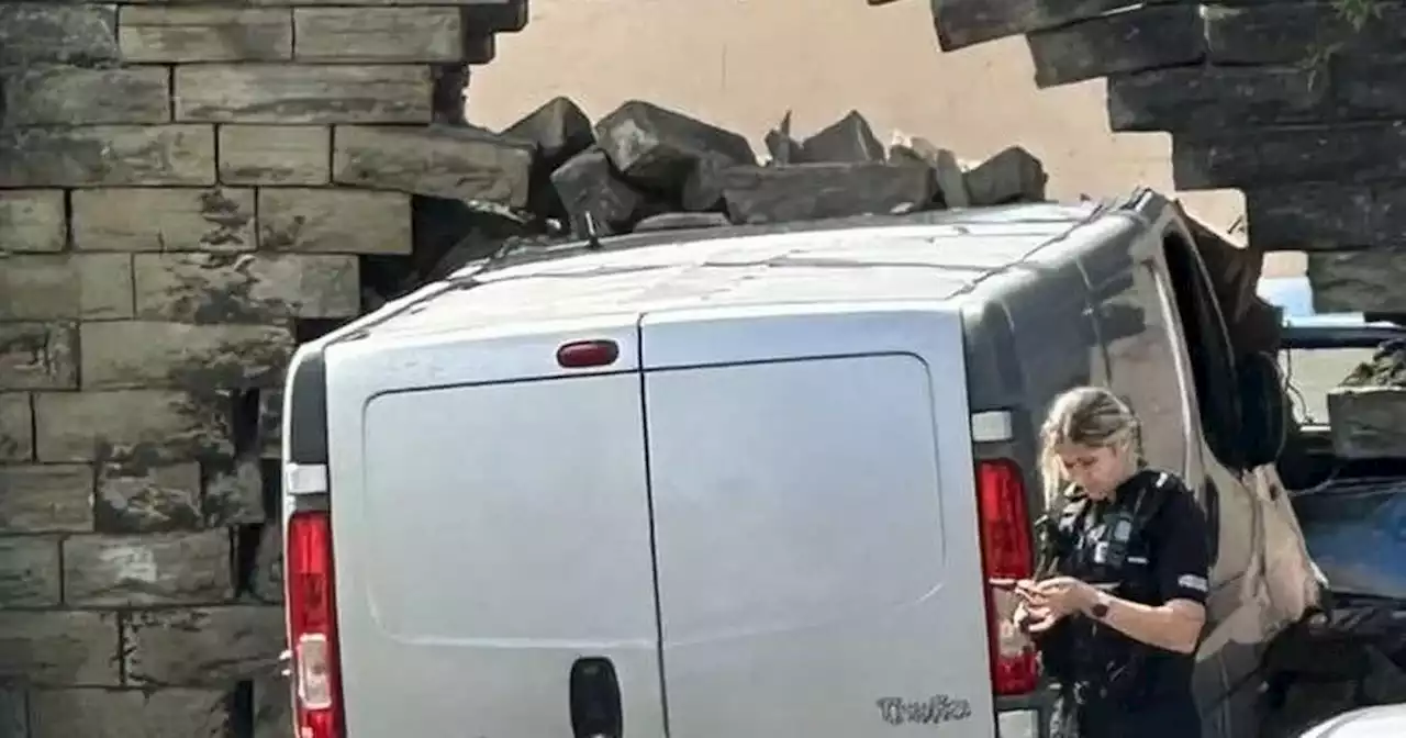 Van crashes through brick wall in Accrington leaving car wrecked