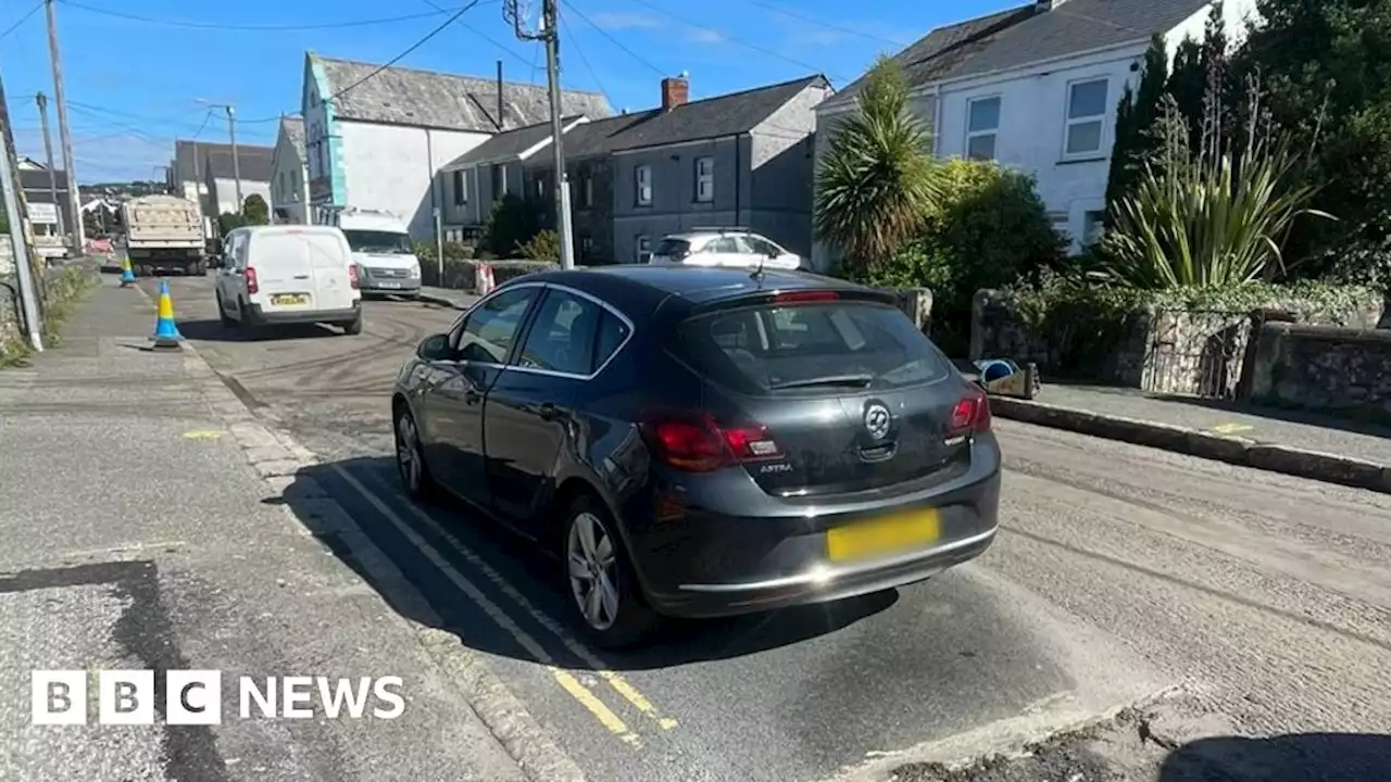 Car moved after roadworks crew resurface road around it