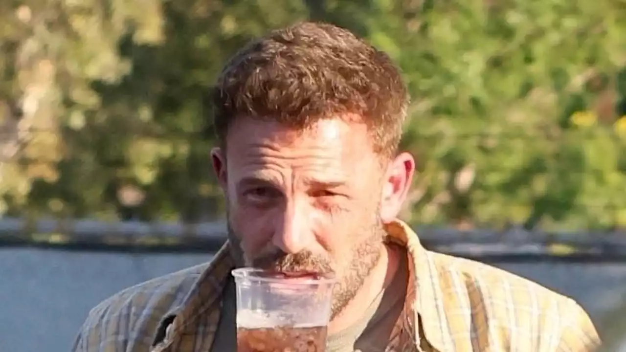 Ben Affleck grips soda cup in his TEETH after his hands were full