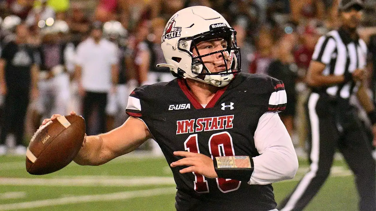 New Mexico State's Diego Pavia tries to make play with helmet twisted around