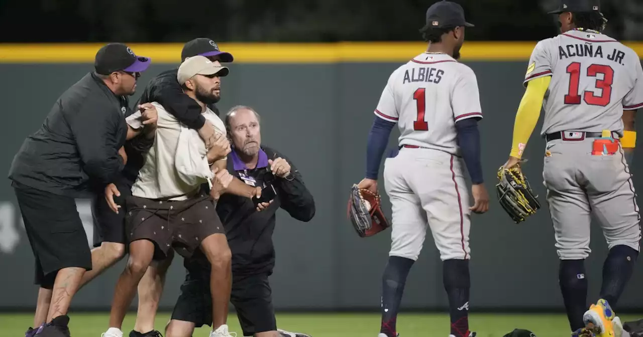 Fans run onto field and one makes contact with Atlanta Braves star Ronald Acuña Jr.