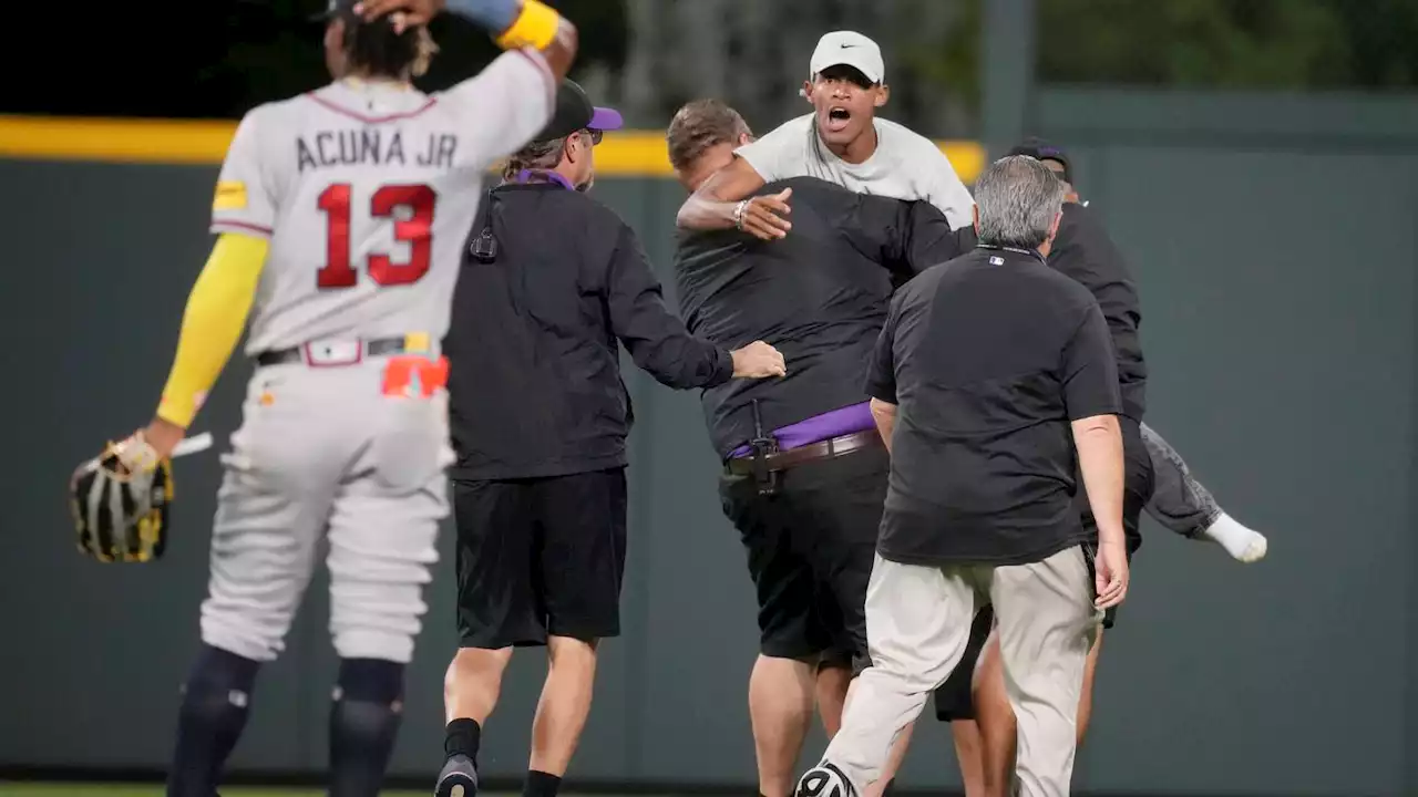 Two fans run onto Coors Field, grab Braves outfielder Ronald Acuña Jr.