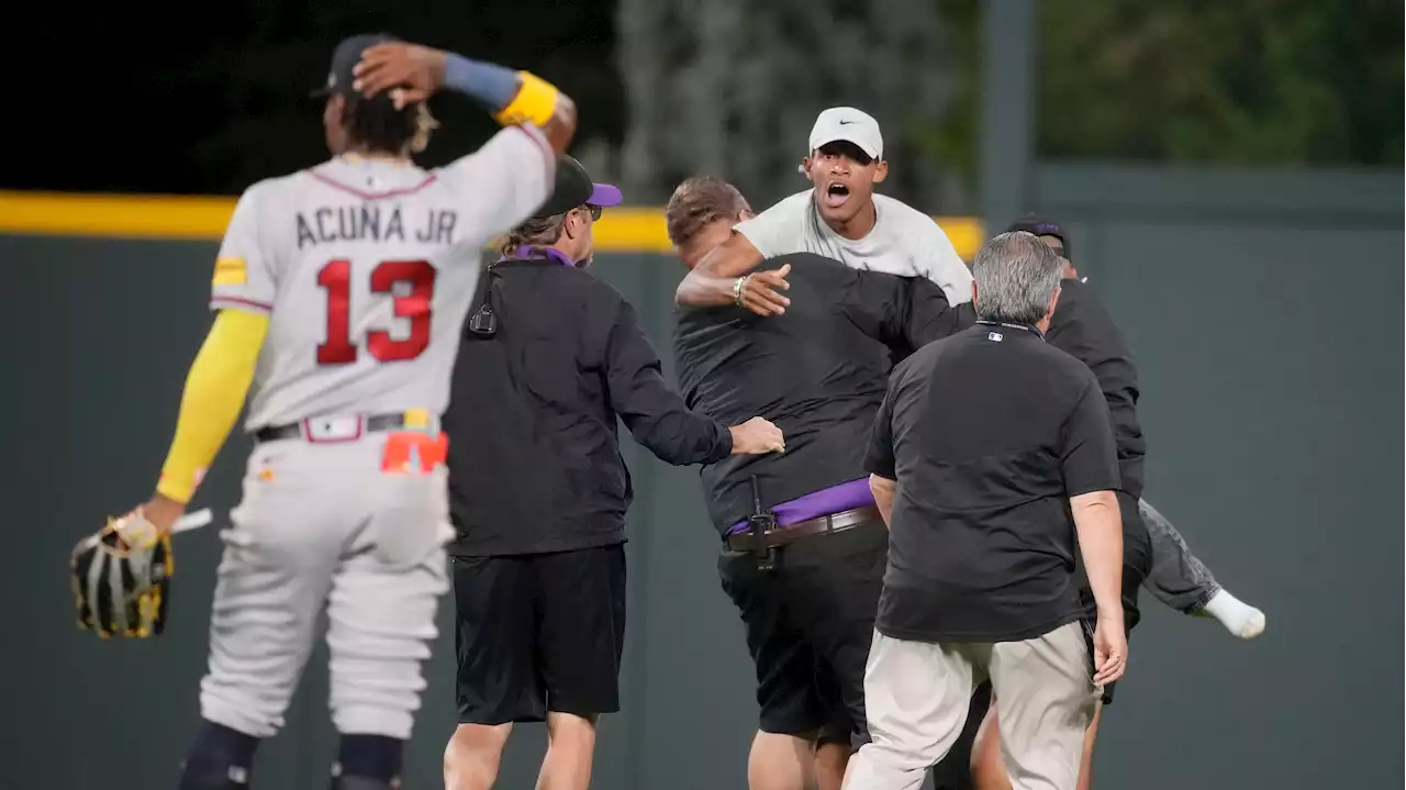 Fans run onto field and one makes contact with Atlanta Braves star Ronald Acuna Jr.