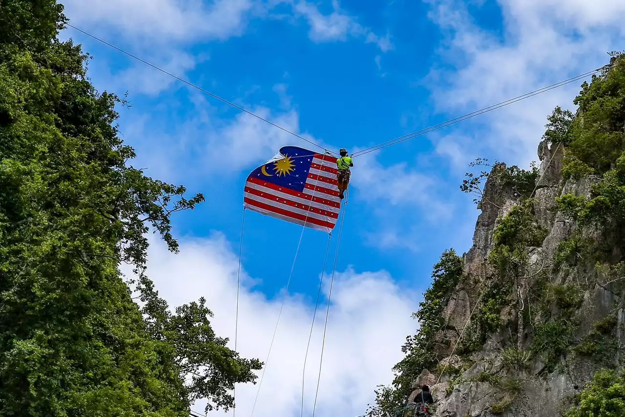 Terapung di sebalik awan biru kibar Jalur Gemilang