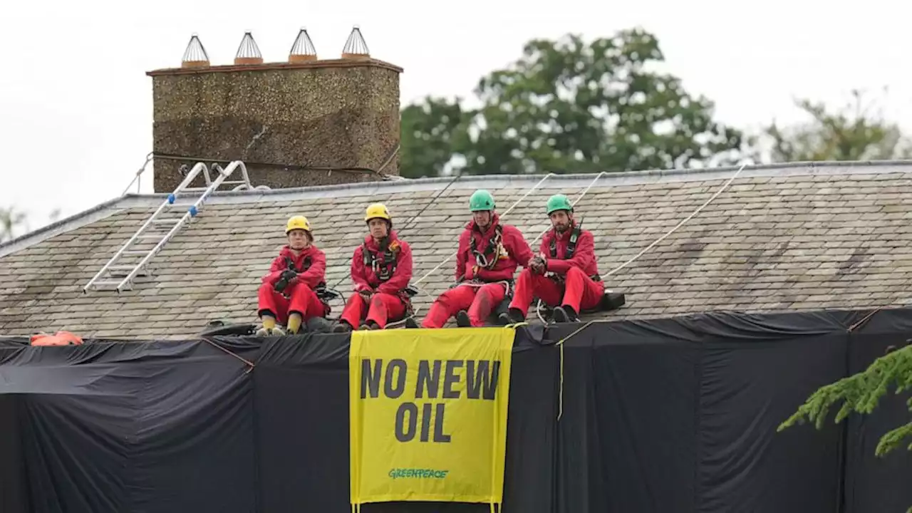 Greenpeace demonstrators drape UK prime minister's house in black to protest oil expansion