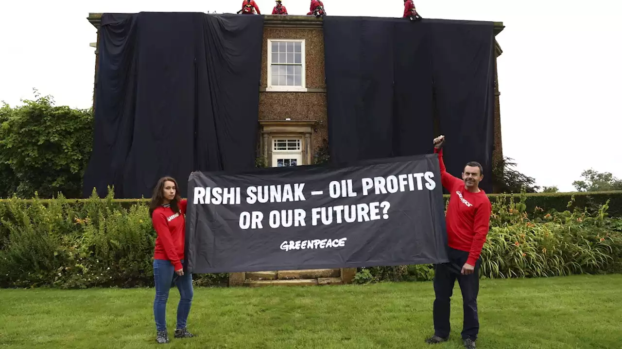 Greenpeace demonstrators drape UK prime minister's house in black to protest oil expansion