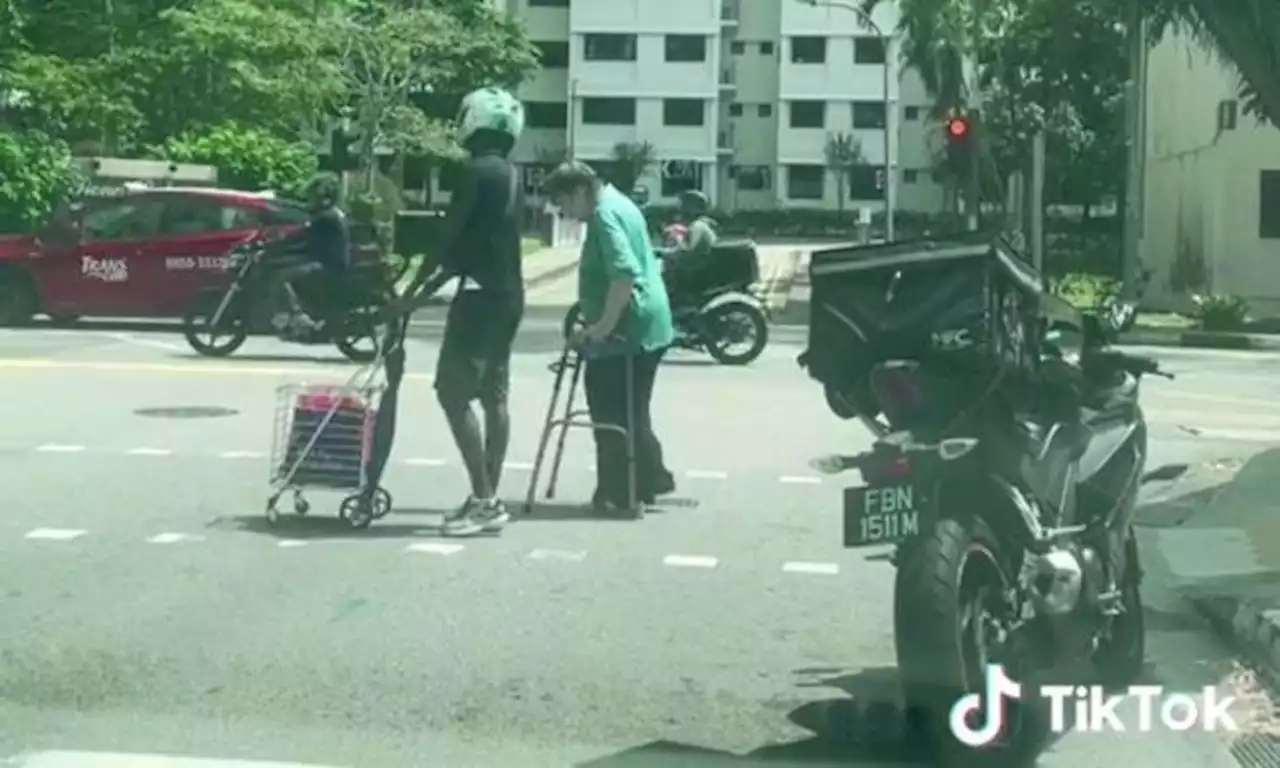 'Really good-hearted' motorcyclist gets off bike to help woman with walker and trolley cross road