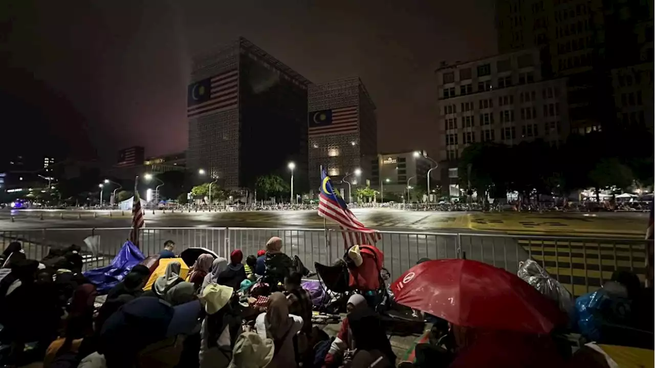 National Day: Downpour doesn’t stop early birds from gathering at Dataran Putrajaya