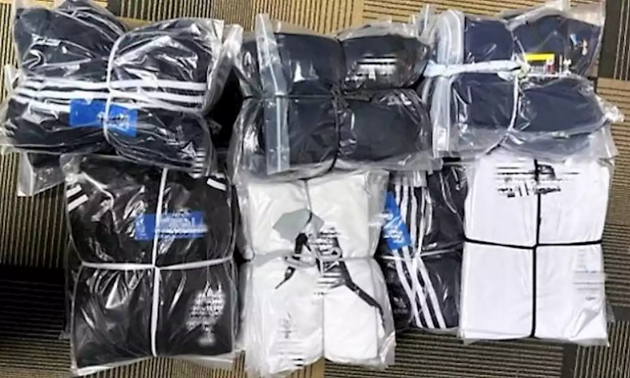 More than 3,900 pieces of counterfeit sports apparel worth over $71,000 seized, 2 men arrested in raids