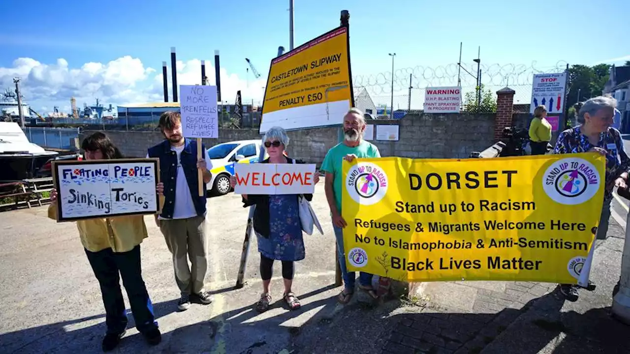 Contentious barge docked on UK coast begins hosting first migrants