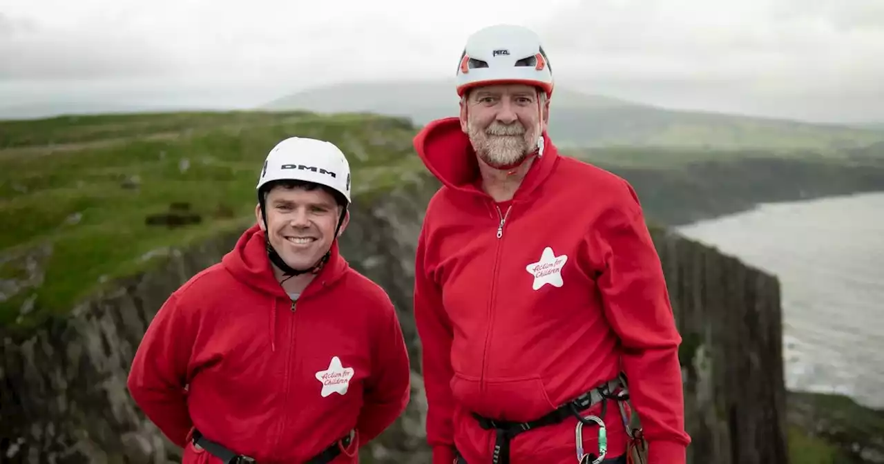 Daring duo spend night dangling from 100m cliff edge to highlight homelessness