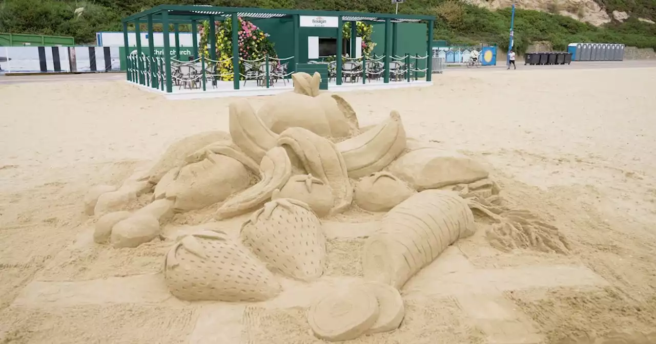 Giant sand sculpture created on beach to represent summer food waste