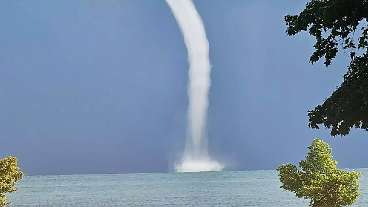 Waterspouts over Lake Michigan; people along shore capture site