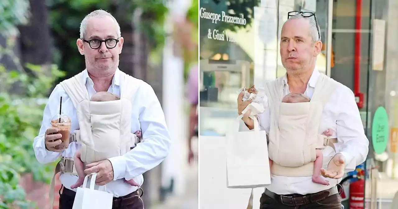 First-time dad Tom Hollander, 56, spotted with newborn strapped to his chest