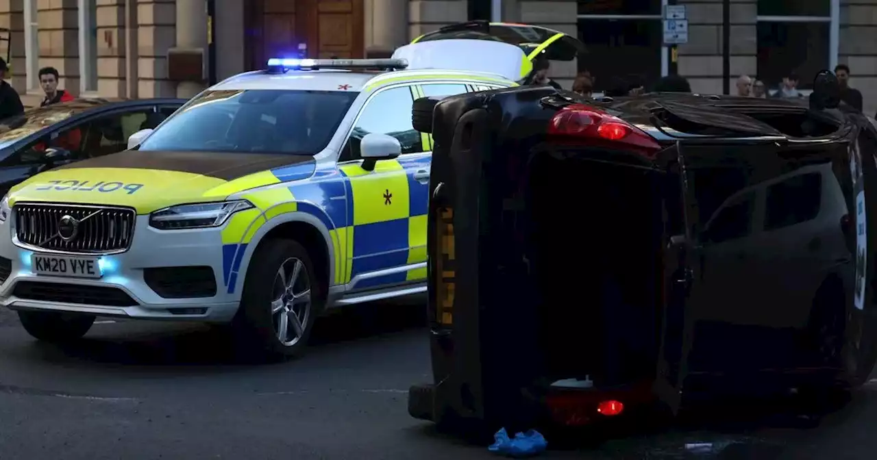 Dramatic pictures as car flips onto side in city centre as witnesses watch on