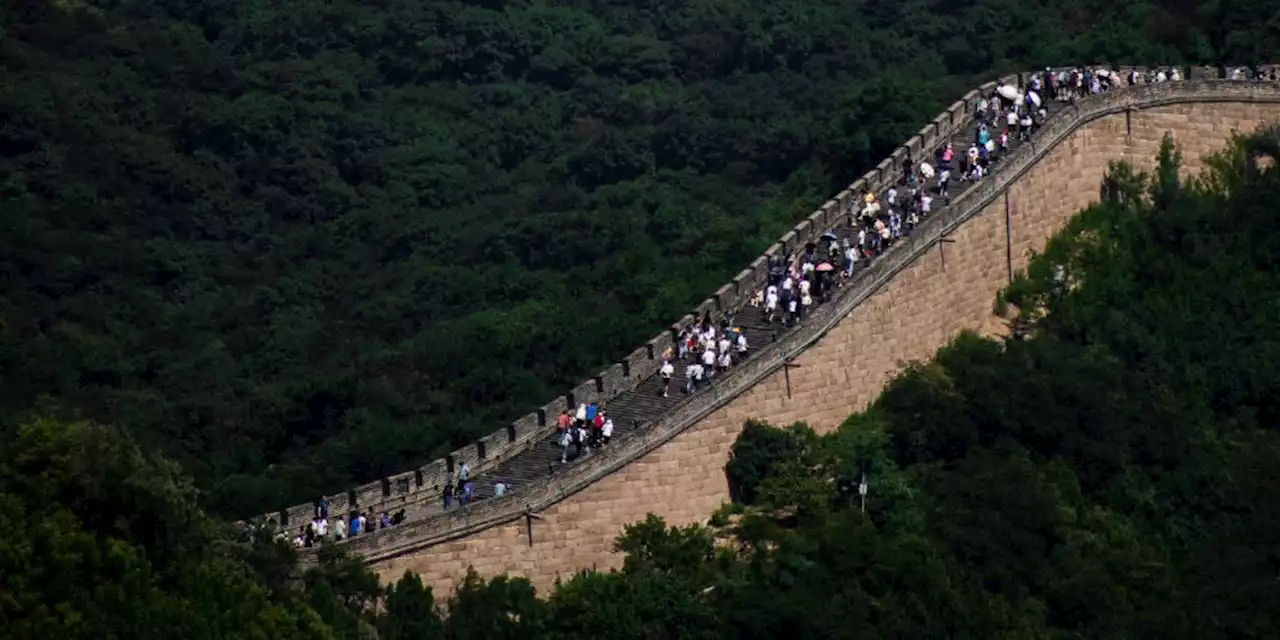 Bauarbeiter schlagen mit Bagger ein Loch in Chinesische Mauer