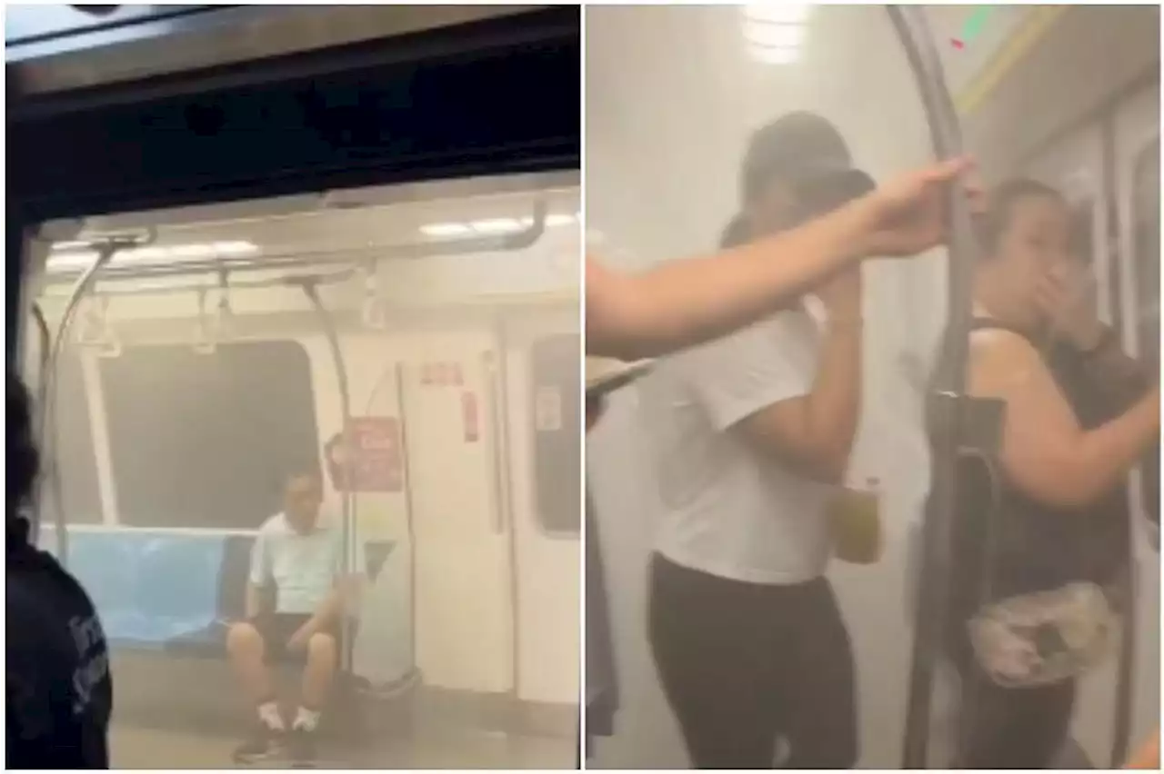 Passengers disembark train at City Hall MRT station after white smoke fills cabin