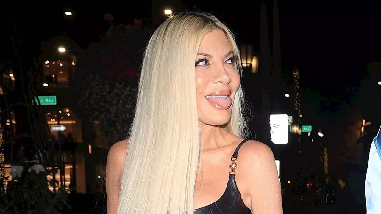 Tori Spelling sticks out her tongue after attending Versace party