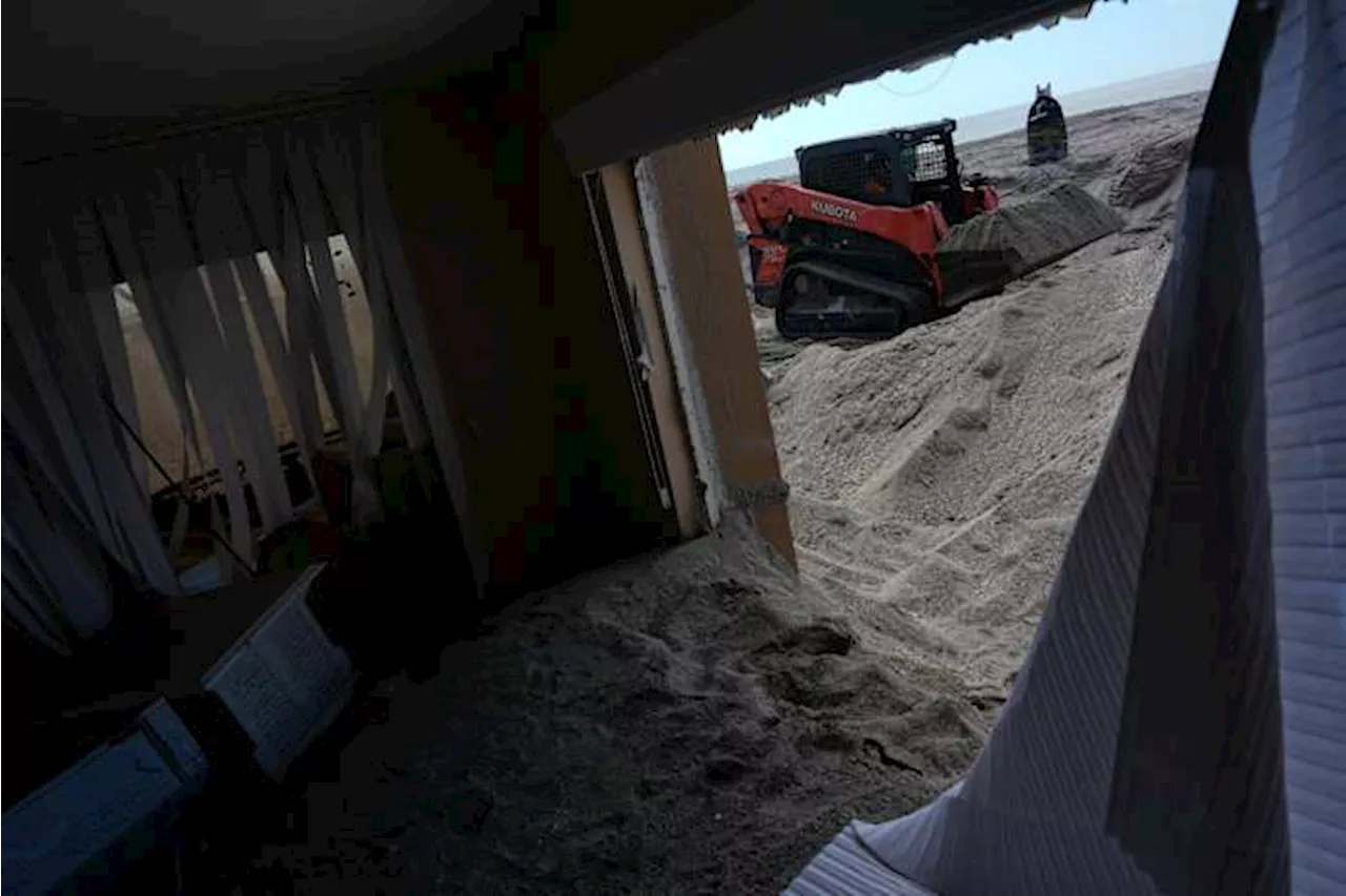 Florida digs out of mountains of sand swept in by back-to-back hurricanes