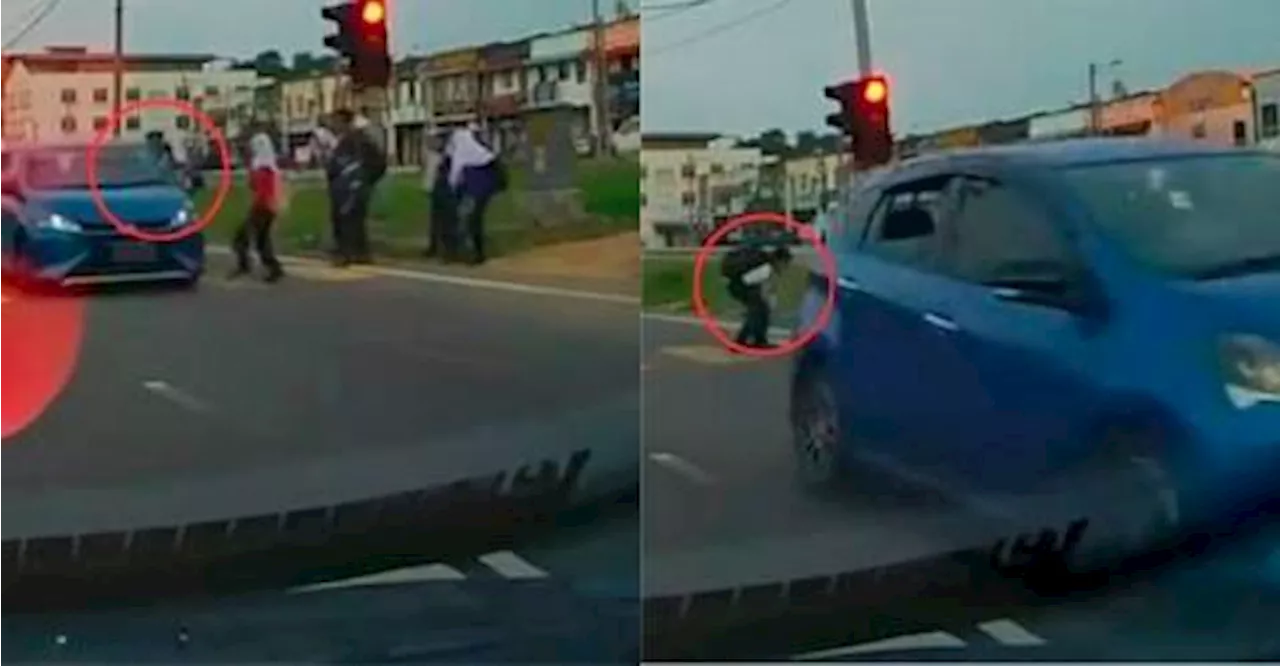 Myvi beats red light, nearly hits student