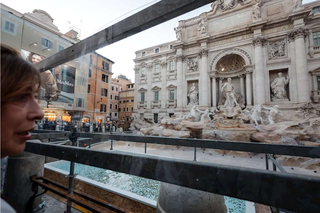 Fontana Trevi senz'acqua, i turisti lanciano le monete in una vasca