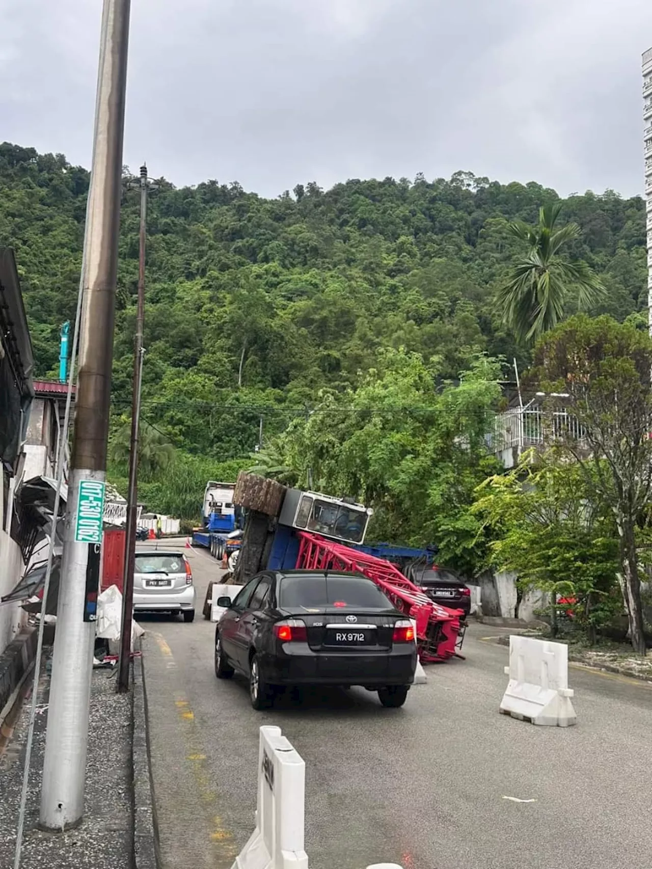 Dua rumah, sebuah kereta rosak dihempap kren