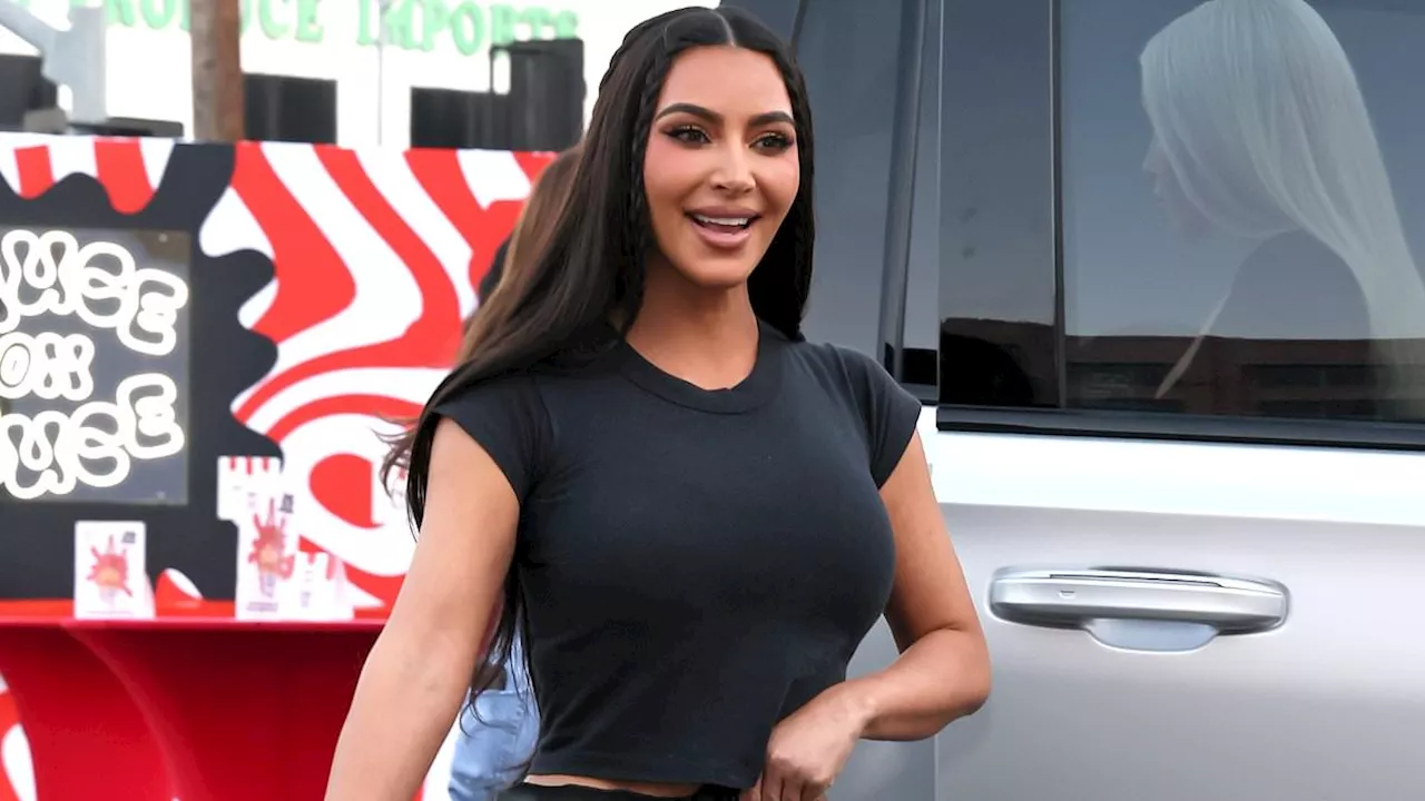 Kim Kardashian rocks a tiny black T-shirt as she and sister Khloe mingle with BJ Novak at ChainFEST...