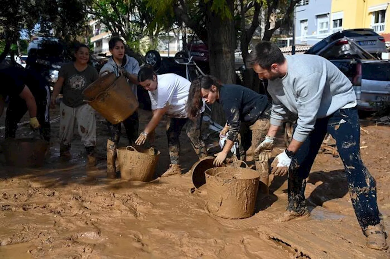 A Valencia in tanti a piedi portano aiuti, i migranti cucinano per gli alluvionati