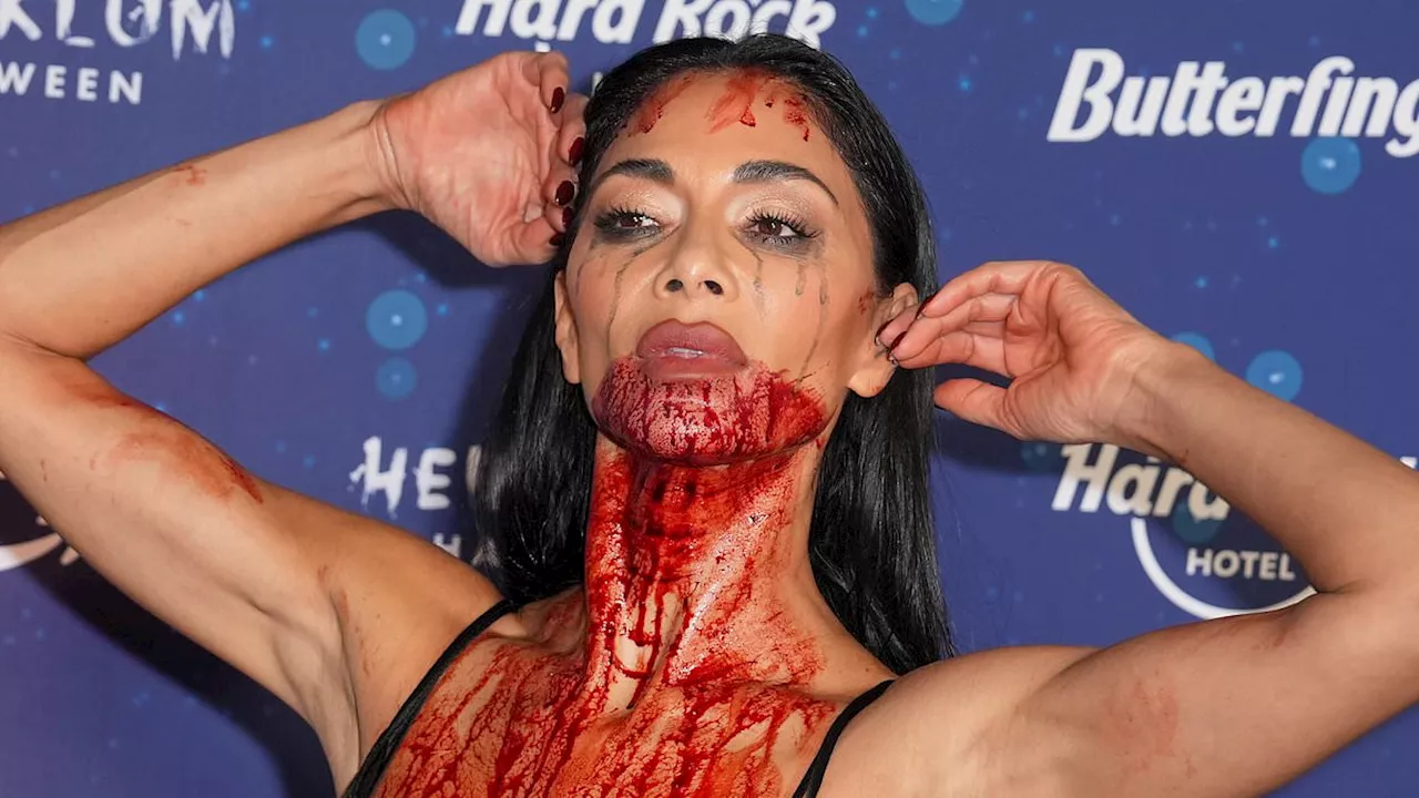 Nicole Scherzinger makes light work of her Halloween costume as she rocks up to Heidi Klum's bash in...