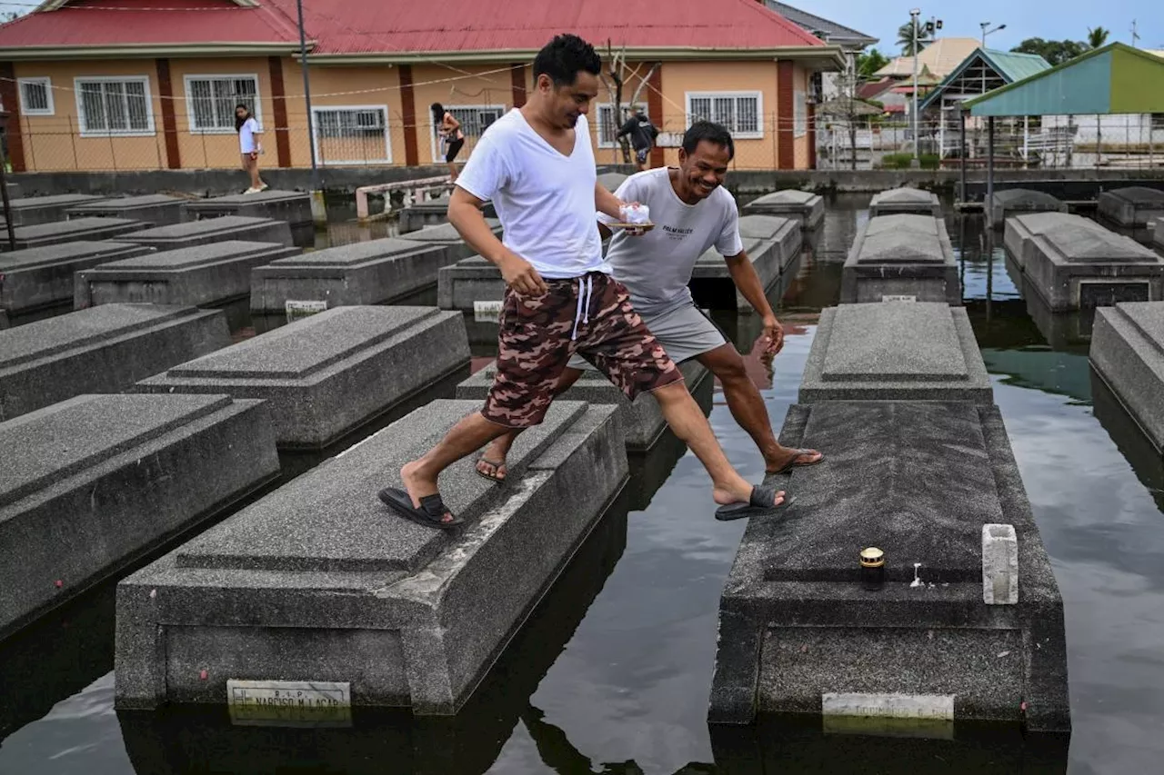 Filipinos brave crowds, flooding for All Saints' Day cemetery visits