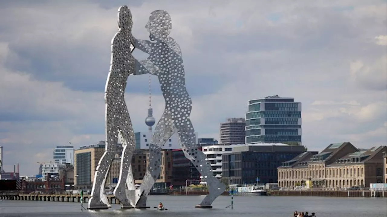 Aktivisten klettern auf Statue 'Molecule Man' in Berliner Spree