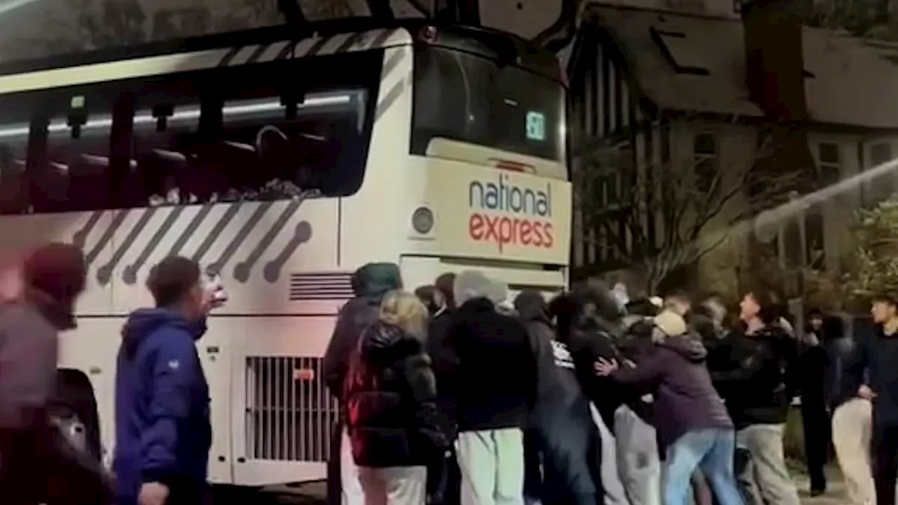 Moment National Express coach on ice saved from sliding down the road uncontrollably by locals