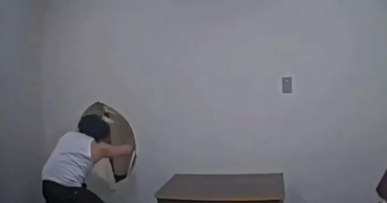 Murder suspect escapes by kicking hole through interrogation room wall