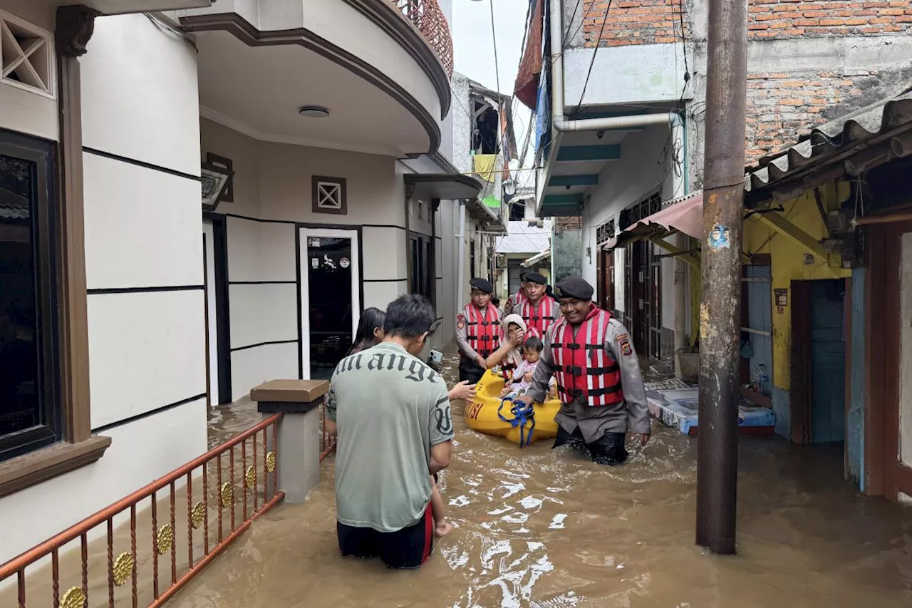 Anggota Polda Metro Jaya Evakuasi Warga Terdampak Banjir di Jakarta Timur