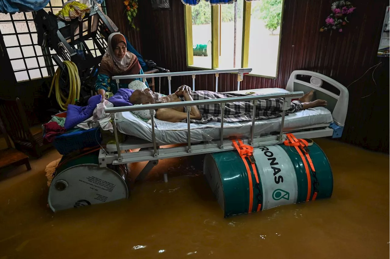 Floods: T'ganu man uses metal drums to keep invalid dad's bed afloat