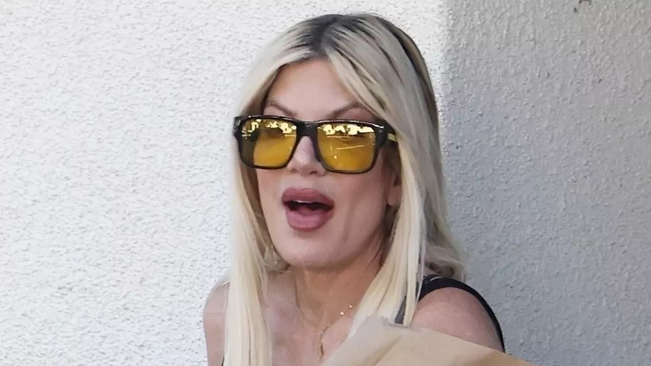 Tori Spelling shows off her new midlife crisis midriff piercing while out in LA