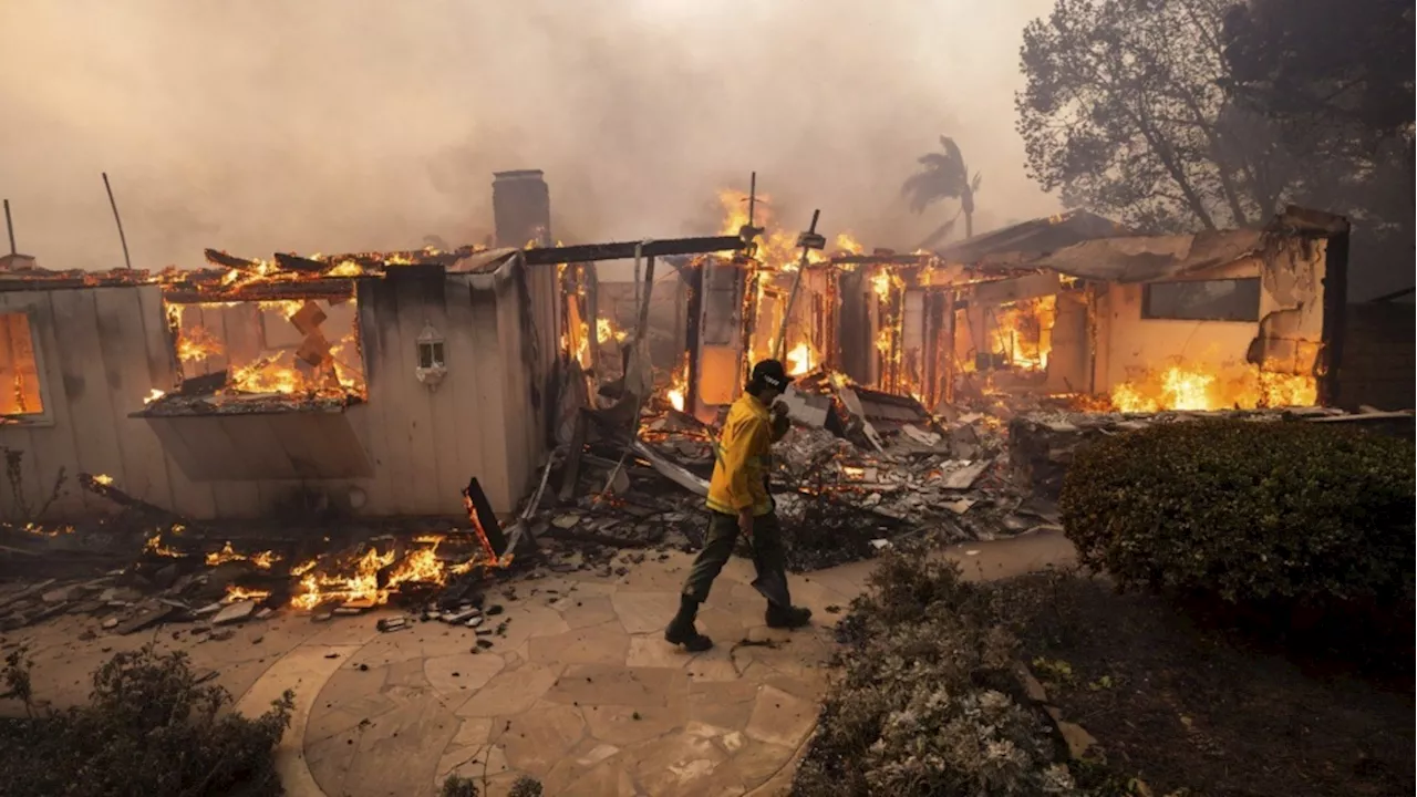 Thousands ordered to evacuate as powerful wind-fed wildfire burns homes in Southern California