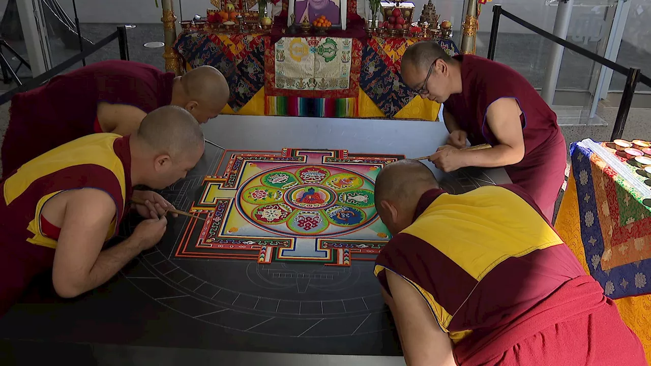 Buddhist monks creating mandala sand painting