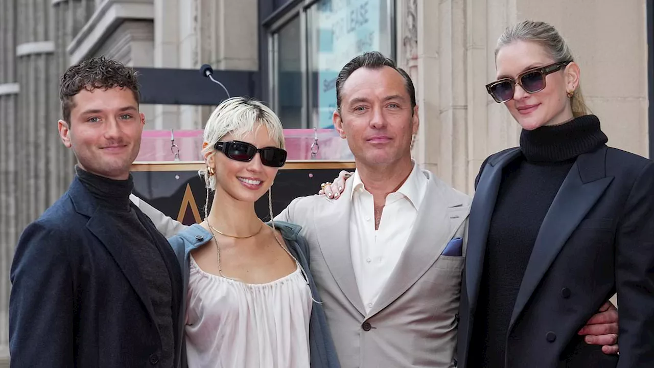 Jude Law, 51, is supported by his children Iris and Rafferty and wife Phillipa, 38, as he is awarded...