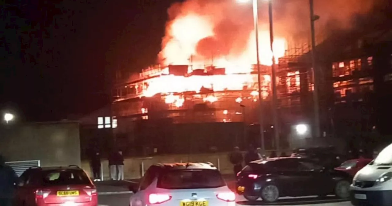 Huge fire rips through new apartments development as crews tackle flames