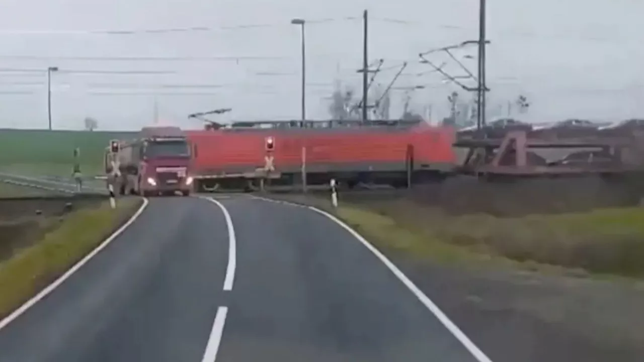 Dramatic moment freight train smashes into stranded truck at level-crossing SECONDS before driver escaped...