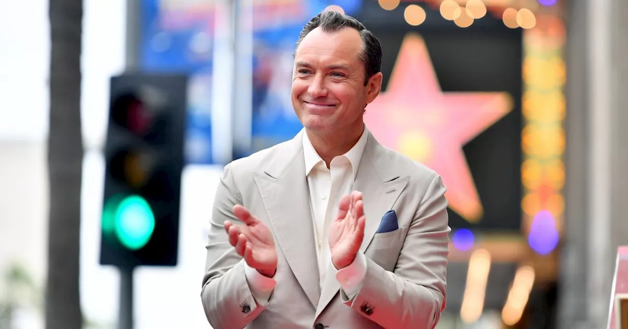 Jude Law's wife towers above him as he poses with rarely-seen kids for honour