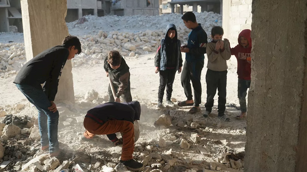 Children dig up bones on street where at least 41 murdered in Syria pit massacre