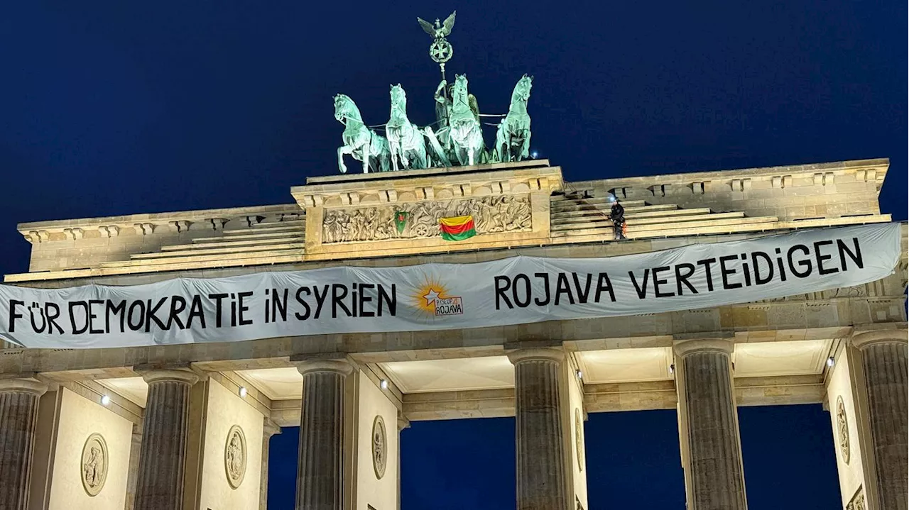 Sie kamen mit einer Hebebühne: Aktivisten entrollen Syrien-Transparent am Brandenburger Tor in Berlin