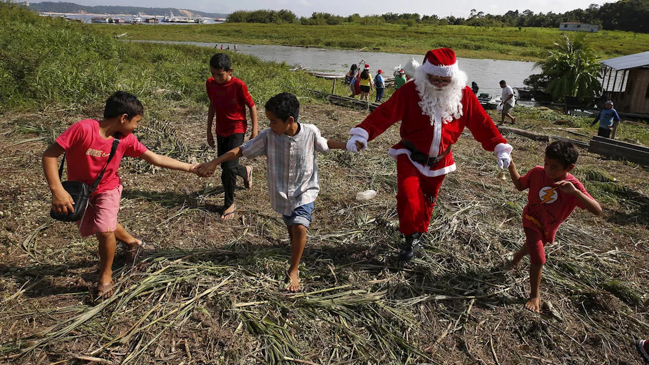 Santa braves sticky heat of Amazon jungle to bring gifts to children