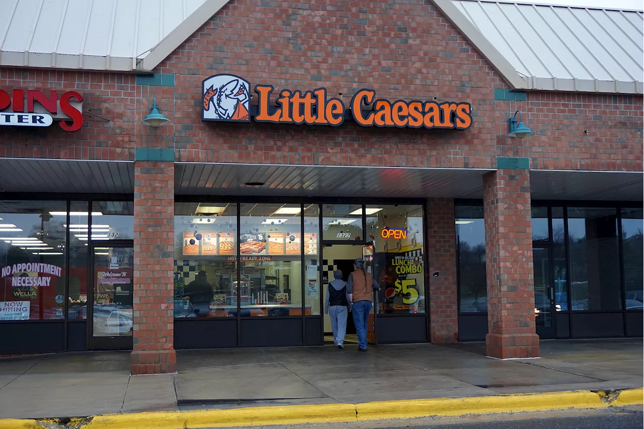 Repartidores en cola ante la alta demanda de pedidos en Little Caesars