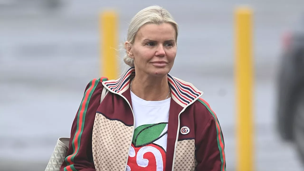 Kerry Katona looks downcast as she arrives at work wearing a £500 Gucci tracksuit after celebrating...