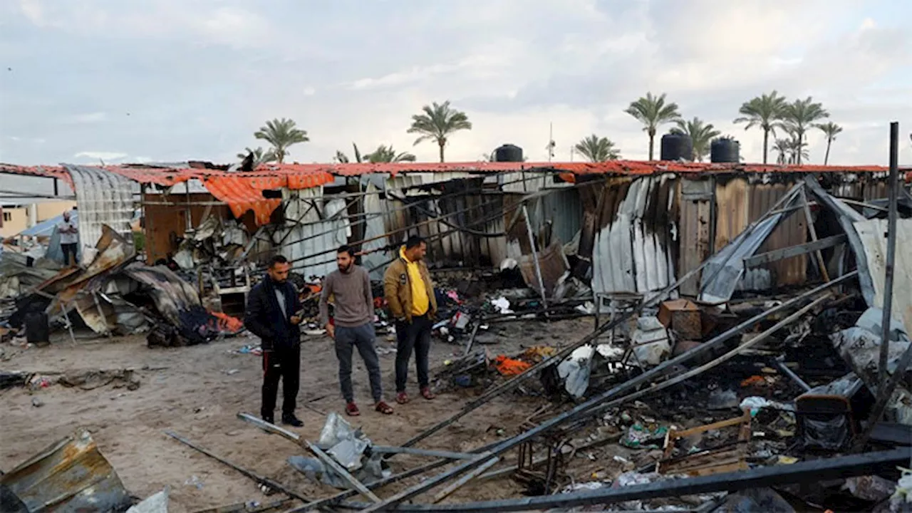 Bereaved Gazans clear shelter remains after deadly camp bombing