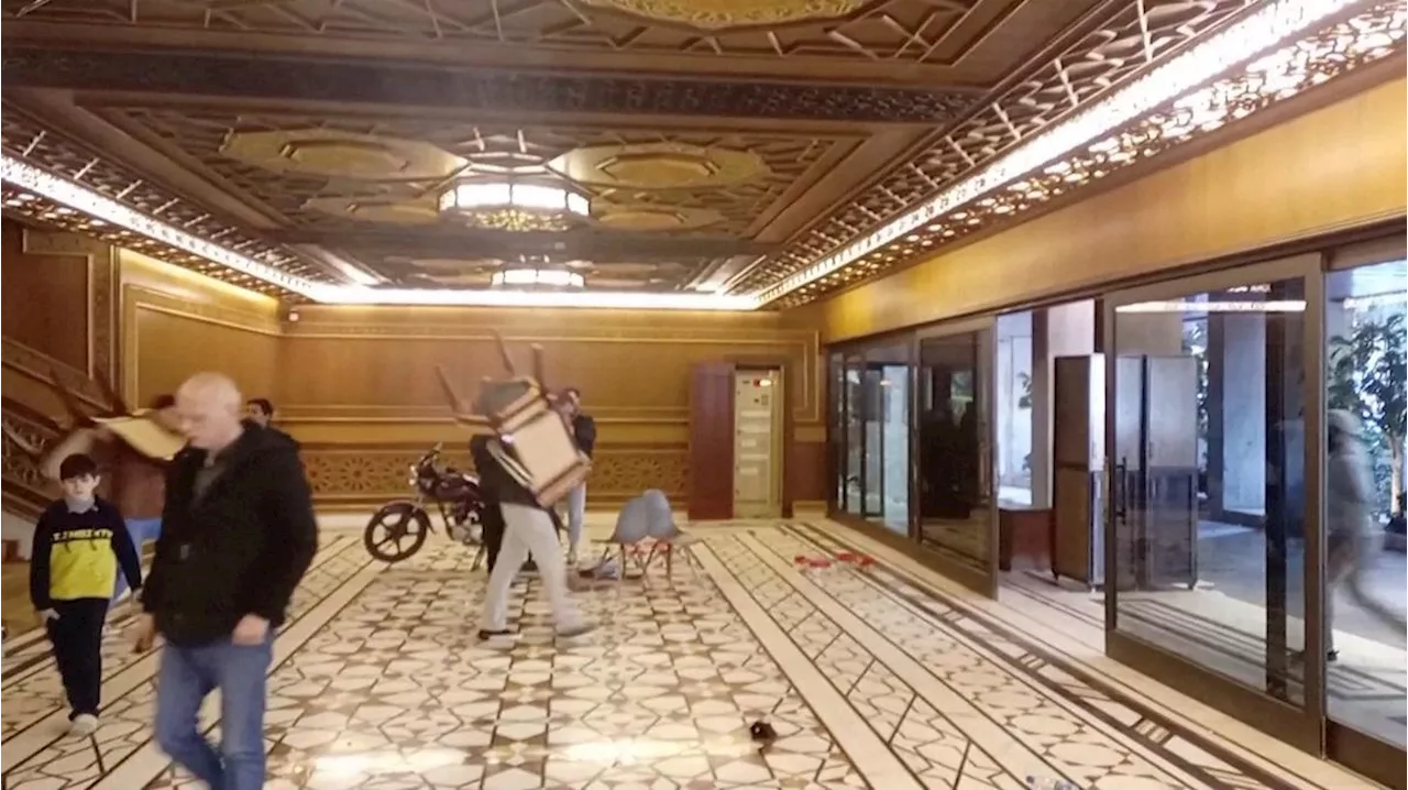 Syrians stroll through Assad’s palaces, take furniture and ornaments