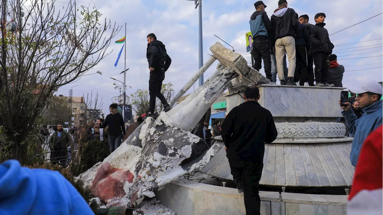 En Syrie : des habitants déboulonnent et piétinent des statues du père de Bachar al-Assad